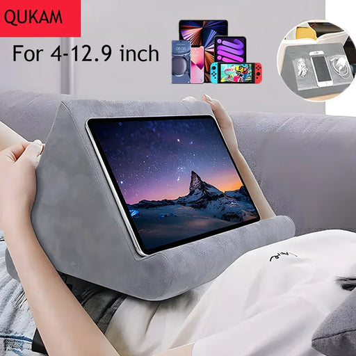 Multifunctional pillow-type tablet and phone holder, suitable for iPad and other devices, made from sponge material for added comfort.